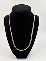 Sterling silver chain displayed on black velvet jewelry bust showing full length and clasp end with close detail on the chain texture