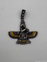 Sterling silver eagle pendant with yellow enamel seen from front.
