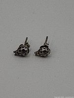 Front view of the pair of sterling silver ladybug stud earrings on a grey background, showing detailed spots.