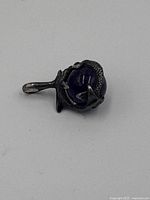 Sterling silver pendant with a dragon wrapped around a deep blue glass sphere, showing front side.