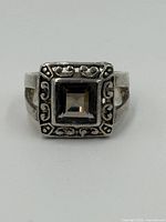 Front view showing square smokey quartz and decorative sterling silver bezel setting with scroll motifs.
