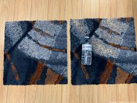 Front view of both square mats showing pattern and scale with water bottle