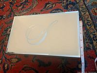 Top view of glass box showing cream lid, silver motif, bevelled mirrored frame, measuring tape for size context