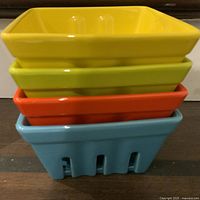 Four ceramic berry baskets stacked showing colors and square shape