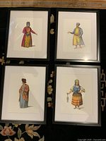 All four framed costume prints laid out together