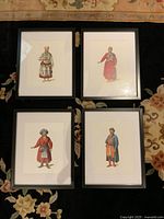Group view of four framed costume prints