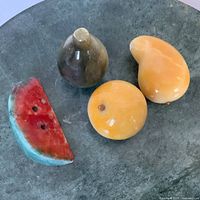 All four stone fruits on green surface