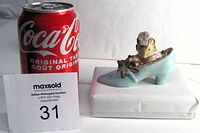Figurine next to Coca-Cola can for size reference, showing mouse figure in blue shoe atop white base.