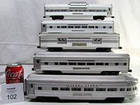 Angled front view of all five cars with Coca-Cola can scale and lot tag