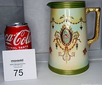 Side view of the Crown Devon antique pitcher next to a Coca-Cola can for size comparison.