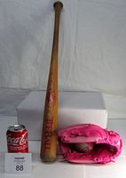Full view of the 26 inch Louisville Slugger wooden Tee Ball bat, pink Wilson glove, and softball beside a soda can for scale