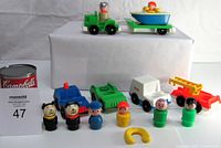 Several vintage Fisher Price toy vehicles and peg figurines arranged on white background showing front and top angle