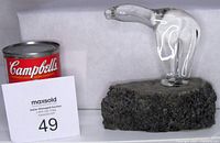 Glass polar bear sculpture next to a Campbell's soup can for size reference.