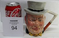 Side view of the sculpted mug showing facial detail, walking stick handle and top hat.