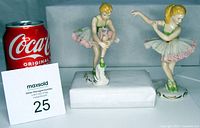 Porcelain ballerina figurines with Coca-Cola can for size reference, showing one figurine adjusting shoe, porcelain lace tutu delicate details.