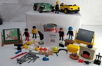 Wide view of Playmobil lot including two vehicles, multiple figures, animals, and accessories arranged on a white surface.