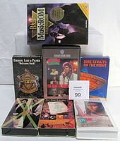Photo of 1 sealed R&B MusicRom CD-ROM and 6 VHS tapes featuring various rock and pop artists and a film VHS tape, arranged for display.