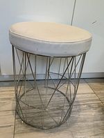 Full view of stool showing chrome base and white cushion