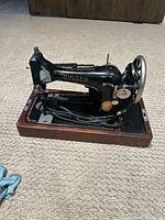 Side view of vintage Singer electric sewing machine on wooden base