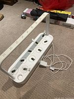 Full view of Click & Grow large smart garden white unit with LED grow light arm and 9 pod slots on base.