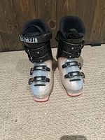 Front view of both Dalbello ski boots on carpet showing toe and buckle area.