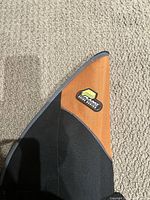 Close-up of orange and black tip of fishing rod case with Plano Pivot Series logo