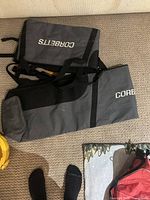 Two gray and black nylon ski bags labeled CORBETTS arranged on carpet.