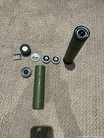 Full contents laid out showing flask, compass, two flask shots, bottle opener, LED light, and batteries.