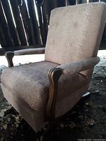 Front right angled view of the vintage 1950s rocker armchair showing fabric upholstery with a floral pattern and wooden armrests.