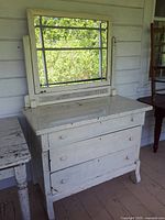 Full view of the white painted dresser with attached framed mirror and three drawers visible, showing overall condition and style.