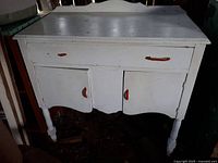 Front view of white pine hutch with single drawer and two cabinet doors featuring red bakelite handles, one handle damaged.