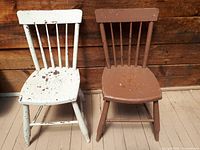 Pair of primitive wooden chairs, one white painted with worn paint and one brown painted, showing rustic use wear and handmade construction