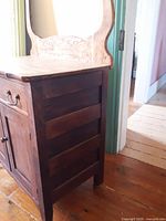 Side view of vintage wooden washstand showing slatted side and wear.