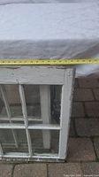 Photo of two vintage farmhouse windows stacked, showing worn white paint and a tape measure indicating approximately 28 inches wide.
