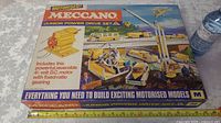 Box of the Meccano Junior Power Drive Set showing a colorful illustration of motorized vehicles and parts outlines, marked as motorised with 4.5 volt DC motor.