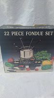 Box front showing 22 piece fondue set with pot, forks, bowls, ladles and burner