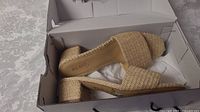 Pair of ALDO ladies' woven block heel summer sandals in open box on white patterned fabric surface.