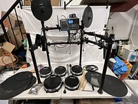 Full kit assembled on rack with module, pads, cymbals, cables, drum sticks