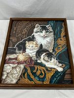 Full view of framed print showing three cats in a detailed upholstery or fabric setting.