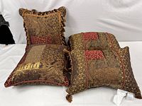 Photo of two ornate decorative pillows together, showing colors and trim details.