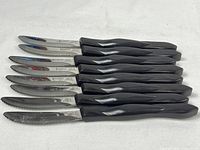 Top view of eight knives aligned handle right