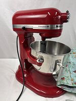 Side view of red mixer with bowl attached and cover draped