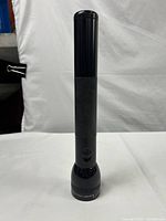 Full view of the 12 1/2 inch Mag-Lite flashlight standing vertically showing the entire body and switch.