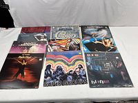 Full overview of all 9 vinyl records laid out on table showing their covers and titles.