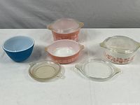 Full lot showing three casserole dishes with lids and three mixing bowls, varying in color and floral decoration.