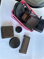 Multiple wooden carved display stands placed in a pink basket and laid out on a white surface.