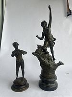 Front view of two figurines against a white background showing full height and form.