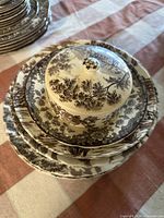 Stacked ceramic dishes and covered butter dish with brown floral toile pattern