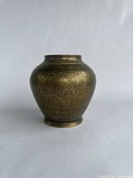 Front angled view of medium brass vase showing engraved design and shape