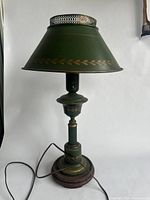 Full view of the green metal lamp with gold leaf pattern on the shade and base showing overall design and structure